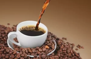 یه فنجان قهوه و دانه‌های قهوه برشته شده