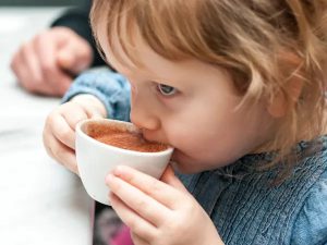 کودکی در حال نوشیدن فنجان قهوه